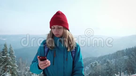 年轻女孩游客在冬天在智能手机上做照片自拍使用智能手机旅行的快乐旅游女孩视频的预览图