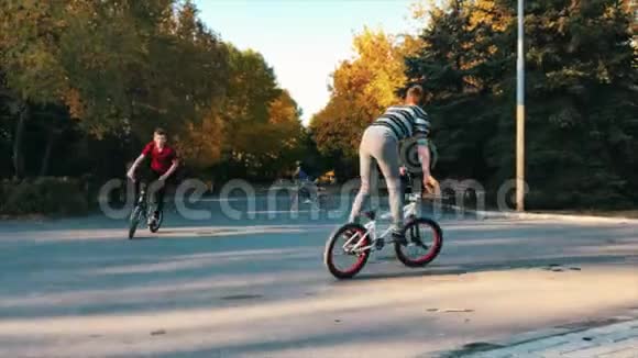 在夏天阳光明媚的公园里极端的bmx骑自行车和跳跃酷小的宝马自行车使奥利魔术视频的预览图