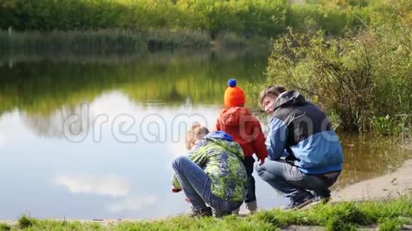 一家人带着孩子在湖边休息在新鲜空气中游走视频的预览图