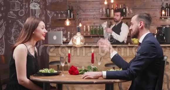 一对夫妇在餐馆里用蜡烛享受浪漫的约会视频的预览图