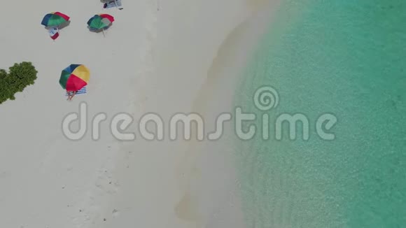 五颜六色的雨伞以防止海滩上的阳光清澈的大海和白沙视频的预览图