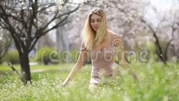 一个年轻的女人快乐享受春天的花朵视频的预览图