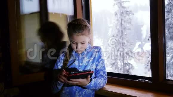 年轻女孩用她的平板电脑视频的预览图