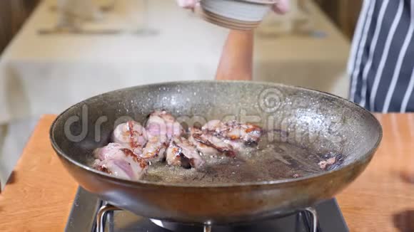 在餐厅的一个热煎锅上加入肝片的厨师烹饪弗拉姆贝式菜肴手套的手视频的预览图