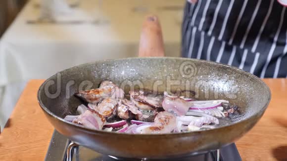 在餐厅的一个热煎锅上加入肝片的厨师烹饪弗拉姆贝式菜肴手拿手套盐视频的预览图