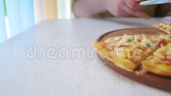 女孩是在一张白色的木桌上的餐馆里在一个白色的盘子里切一个比萨饼多利射击视频的预览图