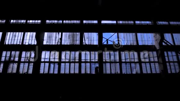 透过古老的灰色工业大厦的窗户向蓝天眺望视频的预览图