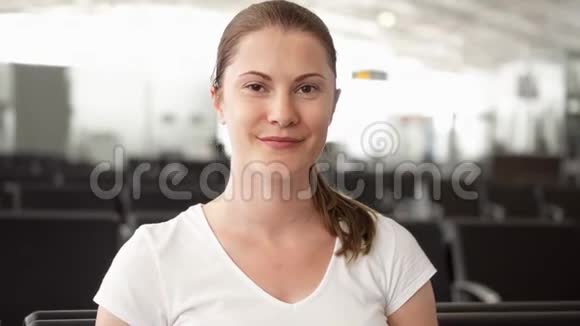 坐在机场候机室的女人的肖像等待航班起飞的女旅客视频的预览图