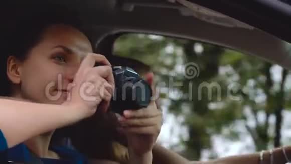两个年轻的女人坐在车里玩得很开心他们中的一个在摄像机上拍照慢动作视频的预览图