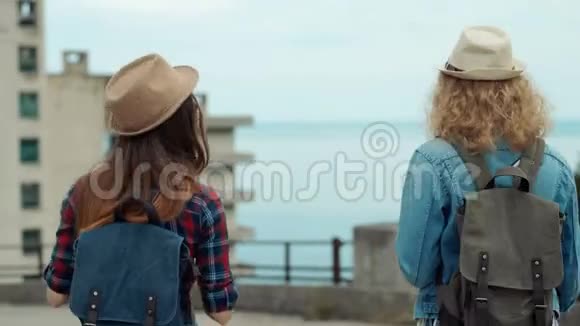 两个漂亮女孩的后景年轻女性朋友户外散步的旅行者视频的预览图