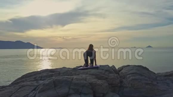 女孩跪在瑜伽台上站在无边的海洋上视频的预览图