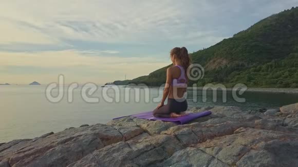 Flycam展示了坐在海边山丘上的女孩视频的预览图