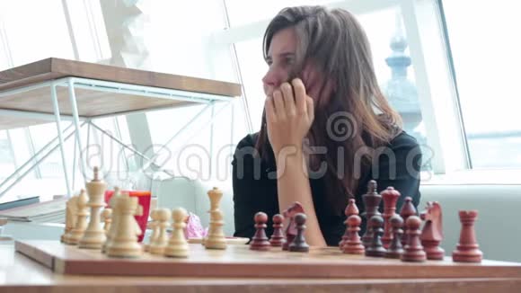 女人在室内下棋和思考位置找到制胜之招策略无聊视频的预览图