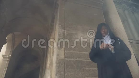 一个修女的鬼魂走过一座古老修道院的废墟4k慢镜头拍摄视频的预览图