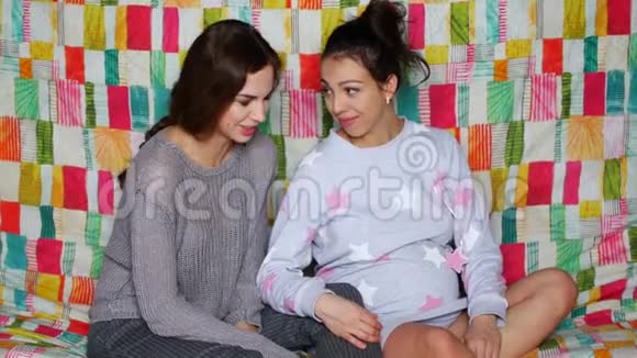 这个女孩正在拜访一个怀孕的朋友美丽的年轻女人谈笑风生视频的预览图