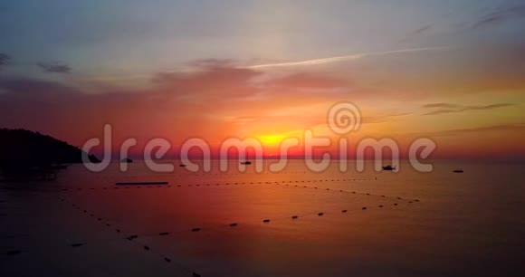 日出时美丽的帆船观夏日清晨平静的海洋自然景象无人机飞行视频的预览图