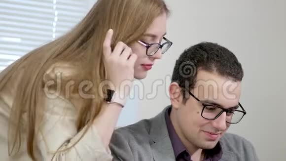 快乐有趣的年轻人男人和女人在办公室玩电脑嘲笑屏幕上的东西视频的预览图