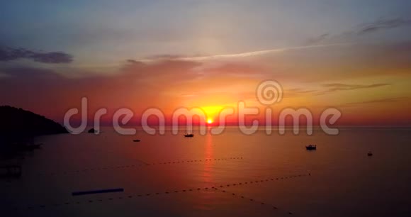 日出时美丽的帆船观夏日清晨平静的海洋自然景象无人机飞行视频的预览图