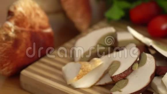 切好的蘑菇躺在砧板上附近有西红柿大蒜绿色沙拉视频的预览图