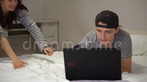 年轻夫妇躺在笔记本电脑前说话视频的预览图