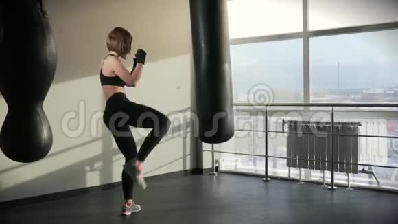 运动女性从事拳击运动在健身俱乐部里训练一个拳击包视频的预览图