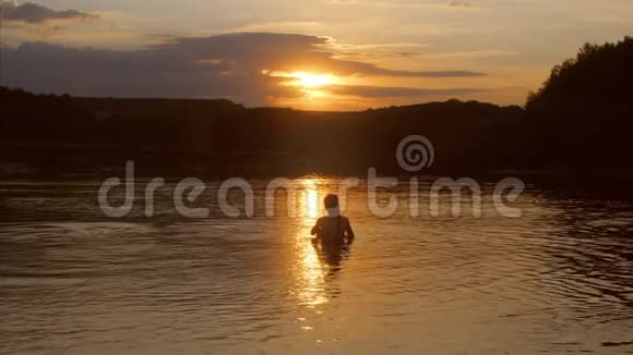 小女孩站在水里看日落视频的预览图
