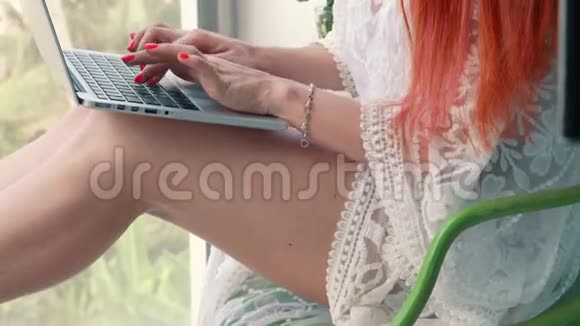 年轻女子在电脑上工作在热带地区放松视频的预览图
