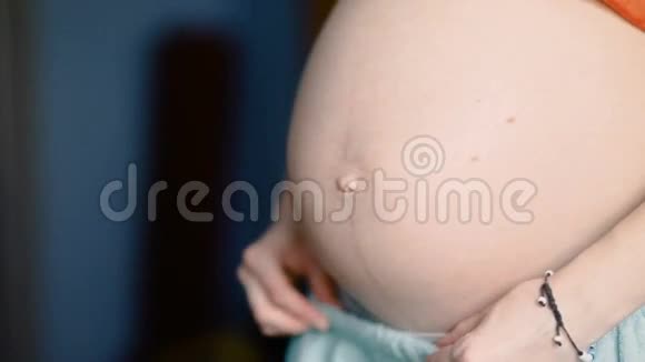 年轻的孕妇用未来的孩子抚摸她的腹部稳住慢镜头视频的预览图