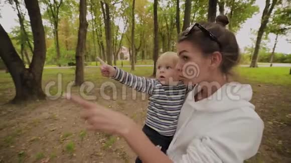 快乐的妈妈和她的儿子在公园里散步视频的预览图