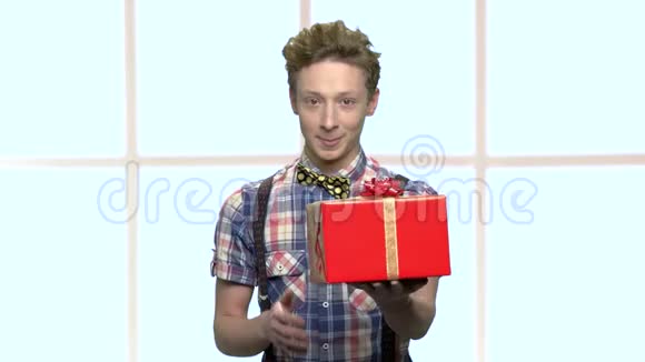 微笑的男孩用丝带送礼物盒视频的预览图
