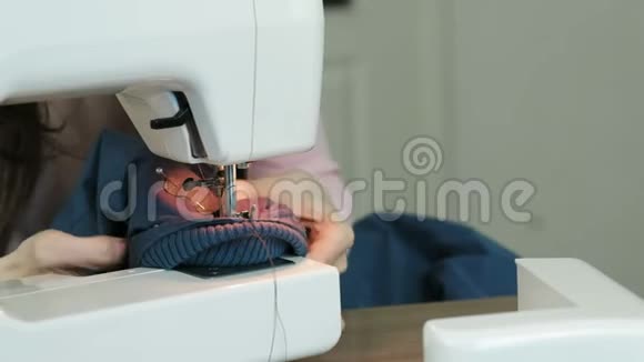 夹在缝纫机里的夹克的特写裁缝试着把它弄出来视频的预览图