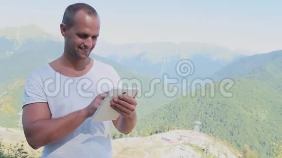 人手触摸山背景上数字平板的屏幕视频的预览图