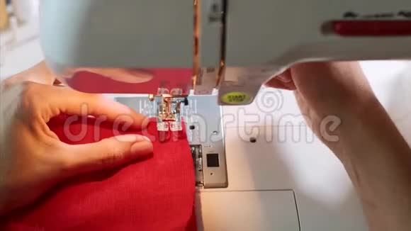 女裁缝手在缝纫机上缝制红色衣服视频的预览图