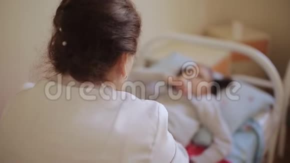 一位老年妇女医生在医院的按摩室里做了一个小腹部按摩女孩视频的预览图