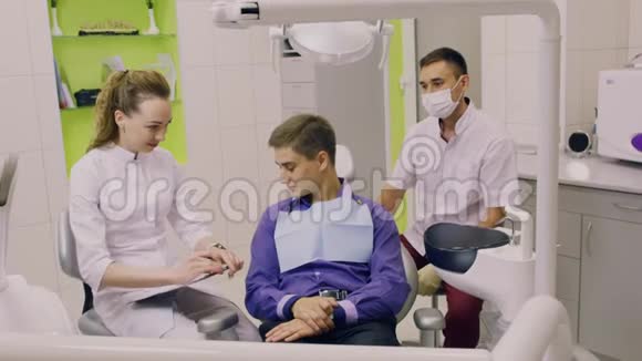 一位牙医和一位助手在诊所为病人工作视频的预览图