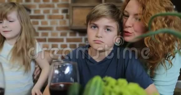快乐的母亲在厨房做饭时拥抱儿子可爱的家庭交流一起准备食物视频的预览图