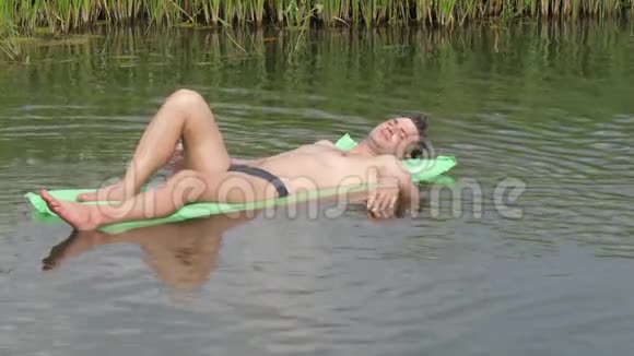 在炎热的夏日里休息在床垫上的河中游泳视频的预览图