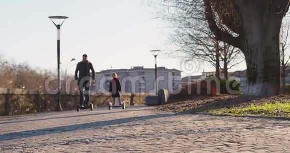 女儿的孩子和她的父亲在城里骑着西格威现代未来运输技术积极的家庭公园人行道视频的预览图