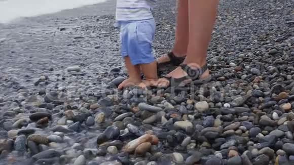 一个小男孩正在海滩上和他的母亲玩耍和散步视频的预览图