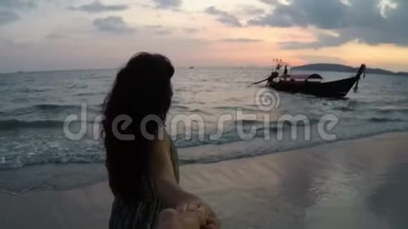 沙滩上的年轻女主角日落时的动作镜头海边快乐的微笑女孩的镜头视频的预览图