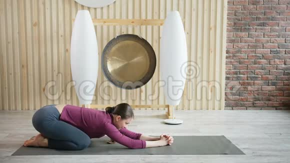 年轻迷人的运动女性在健身房练习瑜伽视频的预览图