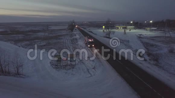 汽油车在冬季公路无人机视图沿路边行驶视频的预览图