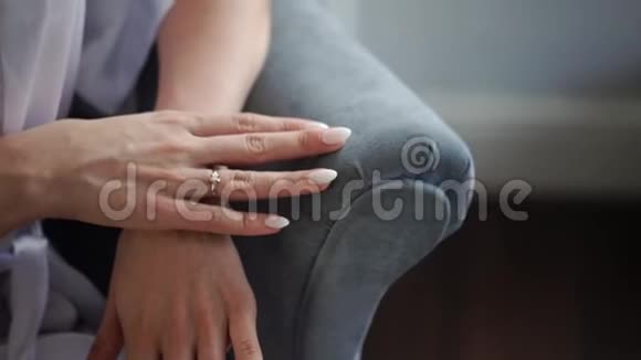 年轻的女强人穿着内衣坐在椅子上双手交叉手指上戴着求婚戒指视频的预览图