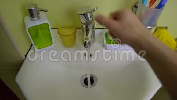 水龙头起重机水龙头的开启和关闭由一个人手在浴室视频的预览图