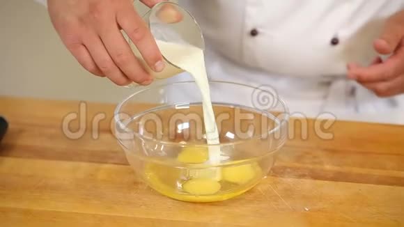 把鸡蛋和牛奶搅拌面团混合在玻璃碗里视频的预览图