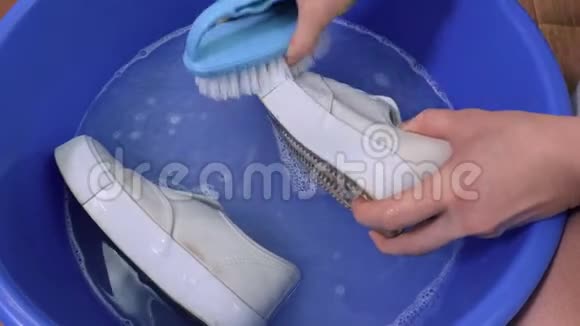 女人洗白色运动鞋视频的预览图