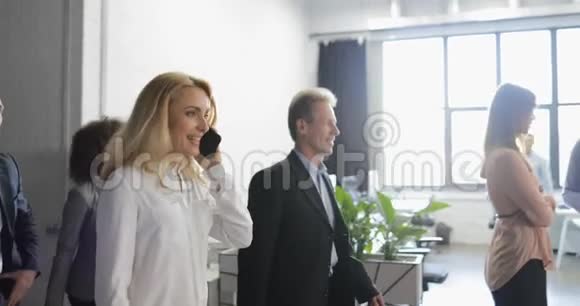 商务人士在现代办公大楼中与商务人士通话的侧视视频的预览图