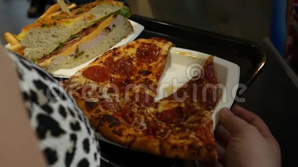 女士排队买一片油腻的意大利香肠披萨和三明治视频的预览图