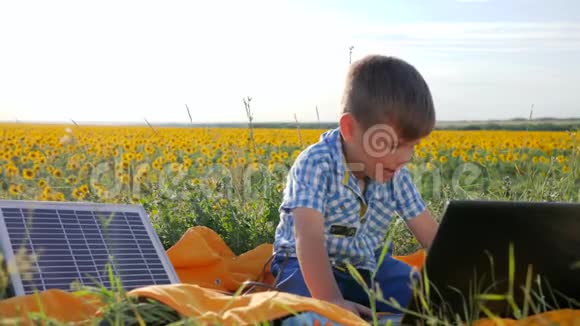 生态孩子在户外看带有太阳能充电器的笔记本能源发电技术现代童年视频的预览图
