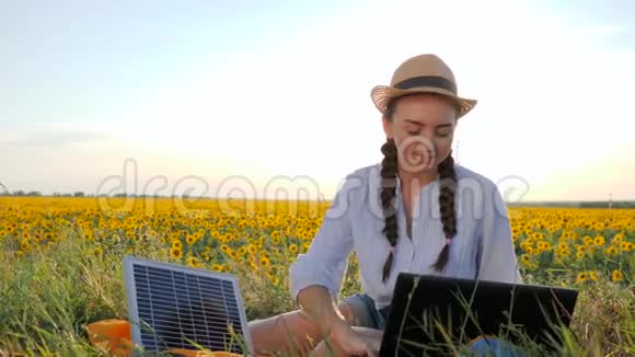 生态年轻女性在户外使用太阳能电池板表现出认可的象征女性在带笔记本充电器的背光视频的预览图
